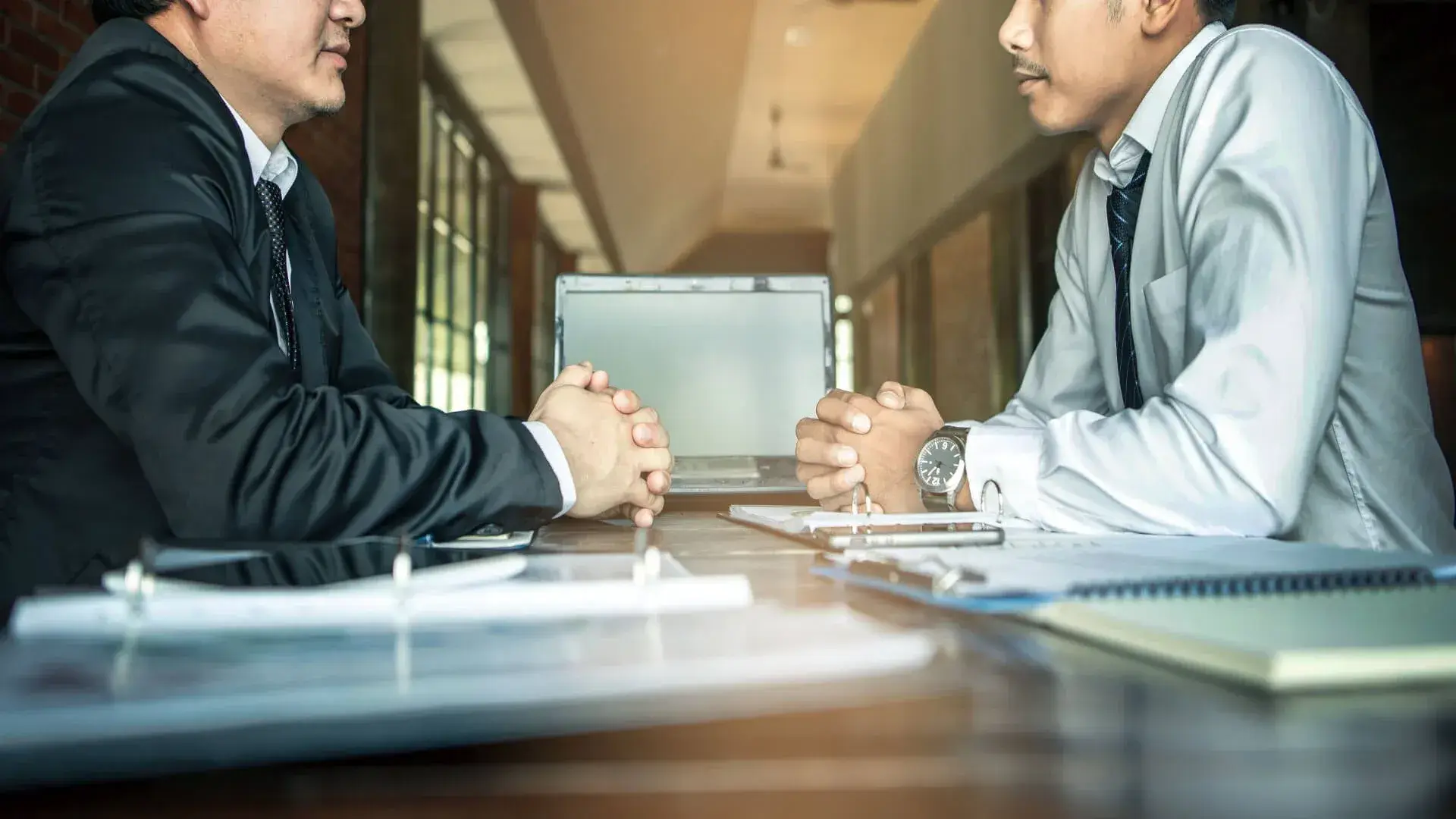 Two advisors going over paperwork with a business owner at a conference table