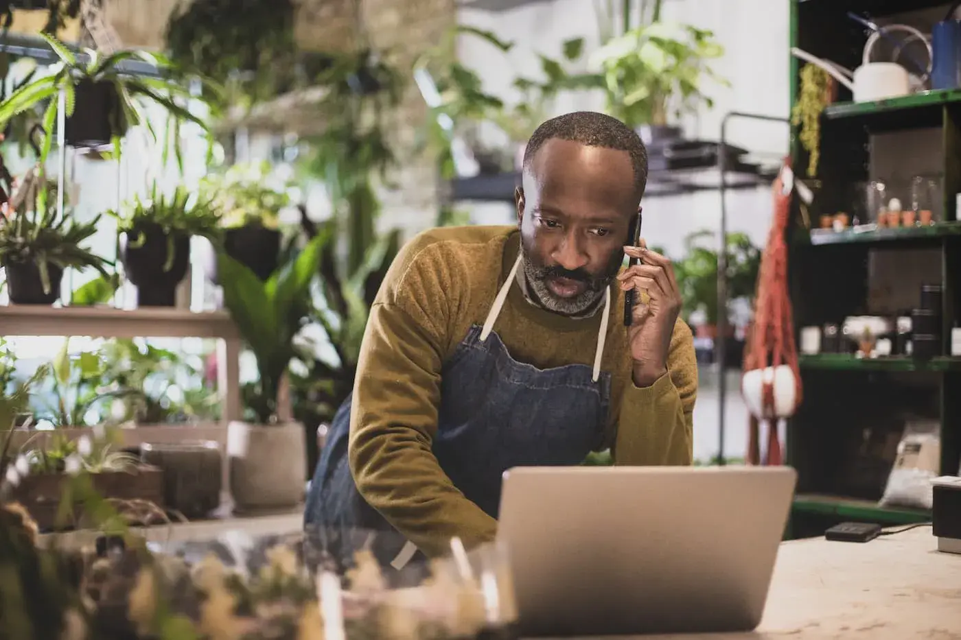 A shop owner on the phone at the counter of a small store